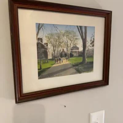 Sale Photo Thumbnail #180: Framed watercolor print depicting the University of Delaware campus in Newark, Delaware, housed in a dark wood frame with a white mat.