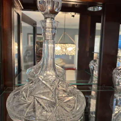 Sale Photo Thumbnail #254: Vintage cut glass ship's decanter with a matching stopper, featuring a pinwheel and starburst pattern.