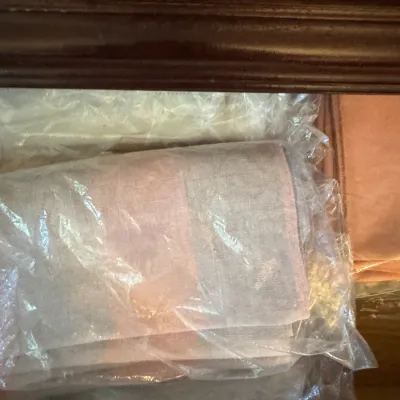 Sale Photo Thumbnail #255: Assorted vintage linens and textiles, individually wrapped in protective plastic bags and stored in a wooden drawer.