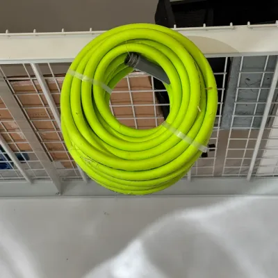 Sale Photo Thumbnail #213: Coiled bright lime green garden hose secured with plastic ties, hanging from a white wire storage shelf.