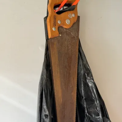 Sale Photo Thumbnail #201: Vintage Stanley hand saw with a carved wooden handle, showing significant surface rust on the blade.