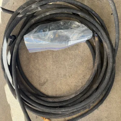 Sale Photo Thumbnail #199: Coiled black rubber garden hose with a plastic bag of hose fittings and connectors.