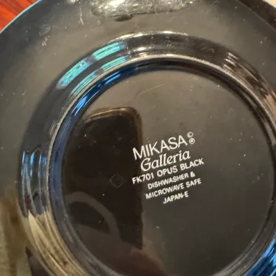 Sale Photo Thumbnail #272: Underside of a Mikasa Galleria 'Opus Black' FK701 ceramic plate, showing the manufacturer's stamp indicating it is dishwasher and microwave safe, made in Japan.