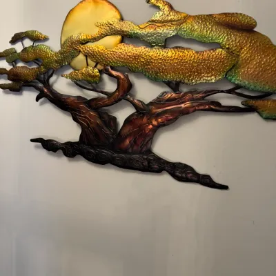 Mid-century modern style metal wall sculpture depicting a bonsai tree silhouetted against a full moon, featuring textured brass, copper,...