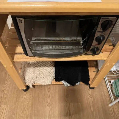 Sale Photo Thumbnail #107: GE toaster oven sitting on a light wood rolling kitchen cart with slatted shelves.