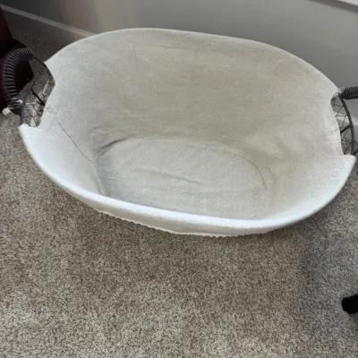 Sale Photo Thumbnail #273: Oval wire laundry basket with a removable light beige fabric liner and wrapped wire handles.