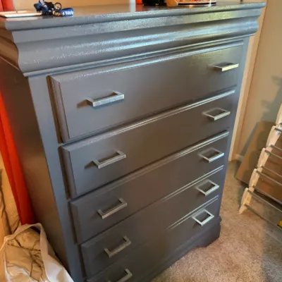 Modern five-drawer chest of drawers painted in a semi-gloss dark gray finish, featuring silver-tone bar pulls.