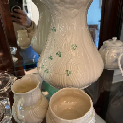 Belleek Irish porcelain shamrock vase with a textured bark design, accompanied by a matching small creamer and open sugar bowl.