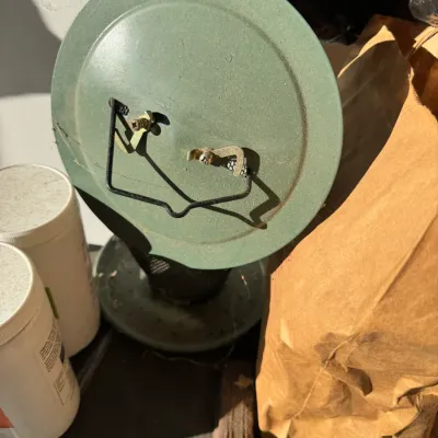 Sale Photo Thumbnail #236: Vintage green metal bird feeder with a wire hanger, showing some wear and dust from outdoor use.