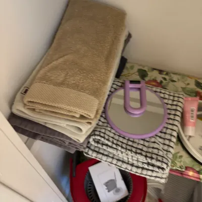 Sale Photo Thumbnail #121: Assorted bath towels in neutral tones, a purple handheld mirror, and a red spin mop bucket with instructions.