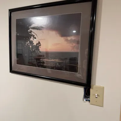 Sale Photo Thumbnail #278: Framed photographic print depicting a tropical sunset over the ocean, housed in a black frame with a wide grey mat.