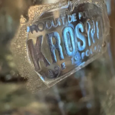 Close-up of a vintage Krosno glass label, reading "Produit de Pologne / Krosno / Made in Poland."
