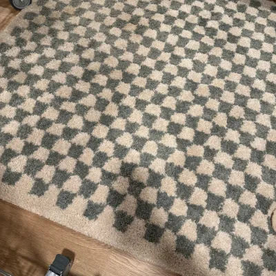 Modern checkered area rug in sage green and cream, featuring a plush, textured pile.