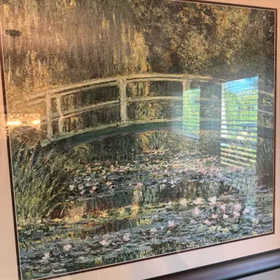 Sale Photo Thumbnail #228: Framed print of Claude Monet's "Water Lilies and Japanese Bridge," presented in a dark wood frame with a neutral mat.