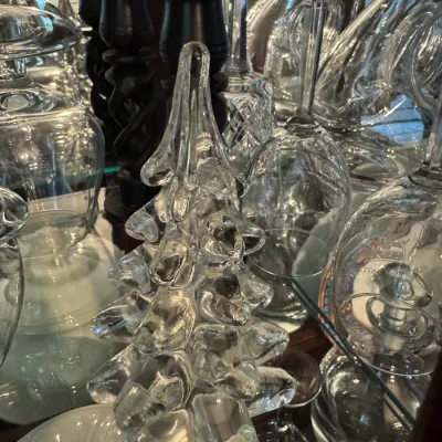 Sale Photo Thumbnail #251: Molded clear glass Christmas tree figurine displayed in a china cabinet alongside various crystal stemware and black wooden candlesticks.