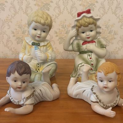 Sale Photo Thumbnail #352: A Group of Four Porcelain Bisque Piano Baby Figurines