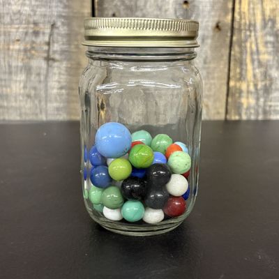 Sale Photo Thumbnail #557: A Collection of Assorted Glass Marbles in a Clear Glass Jar