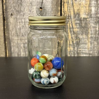 Sale Photo Thumbnail #303: An Assortment of Vintage Glass Marbles in a Graduated Glass Storage Jar