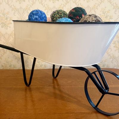 Sale Photo Thumbnail #257: Large Decorative White Metal Wheelbarrow with Assortment of Fabric Rag Balls