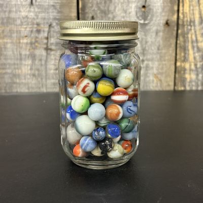 Sale Photo Thumbnail #559: A Collection of Vintage Machine Made Glass Marbles in a Graduated Glass Jar