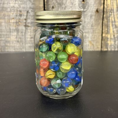 Sale Photo Thumbnail #562: A Collection of Assorted Glass Marbles in a Clear Glass Storage Jar