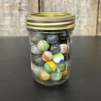Sale Photo Thumbnail #764: A Collection of Assorted Vintage Glass Marbles in a Clear Glass Storage Jar