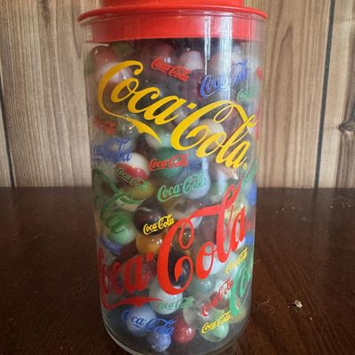 Sale Photo Thumbnail #211: A Collection of Assorted Glass Marbles in a Coca-Cola Advertising Canister