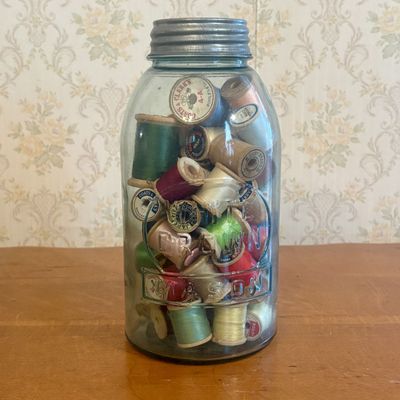 Sale Photo Thumbnail #133: An Assortment of Vintage Wooden Thread Spools in a The Crown Mason Glass Jar