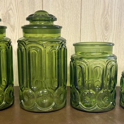 Sale Photo Thumbnail #678: A Set of Four Green Pressed Glass Moon and Star Pattern Canisters