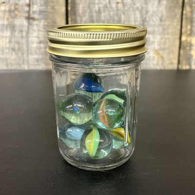 Sale Photo Thumbnail #771: A Collection of Eight Large Glass Shooter Marbles in a Mason Jar