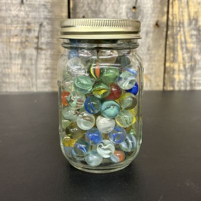 Sale Photo Thumbnail #555: A Collection of Vintage Glass Marbles in a Graduated Storage Jar