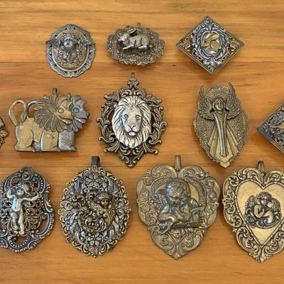 Sale Photo Thumbnail #617: A Collection of Metal Scarf Slides and Decorative Pendants Featuring Animal and Cherub Motifs