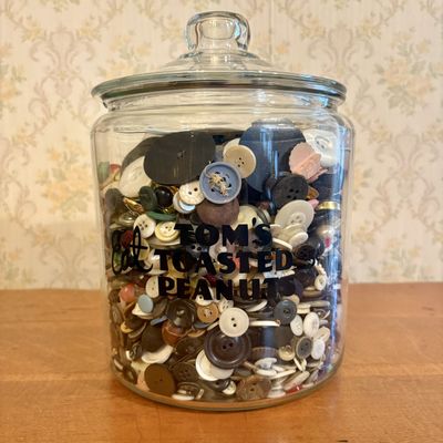 A Collection of Vintage Sewing Buttons and Notions in a Tom's Toasted Peanuts Glass Jar