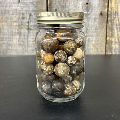 Sale Photo Thumbnail #658: A Collection of Natural Stone and Clay Marbles in a Clear Glass Jar