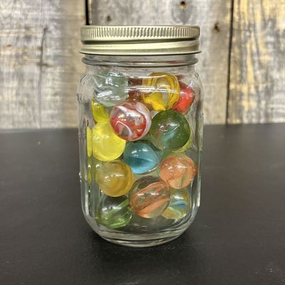 Sale Photo Thumbnail #554: A Collection of Assorted Glass Marbles in a Graduated Glass Jar