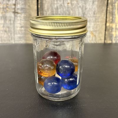 Sale Photo Thumbnail #770: A Collection of Vintage Handmade Glass Marbles in a Clear Glass Storage Jar