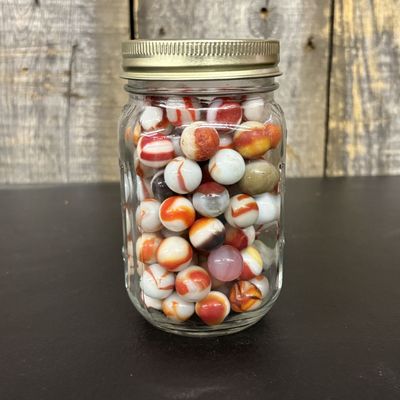 Sale Photo Thumbnail #649: A Collection of Vintage Glass Swirl and Patch Marbles in a Graduated Glass Jar