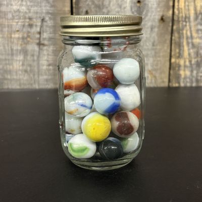 Sale Photo Thumbnail #552: A Collection of Vintage Machine-Made Glass Marbles in a Clear Utility Jar