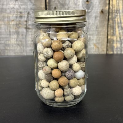 Sale Photo Thumbnail #661: A Collection of Antique Clay Marbles in a Graduated Glass Jar