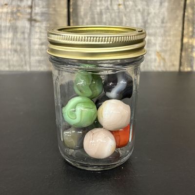 Sale Photo Thumbnail #762: A Collection of Vintage Glass Marbles in a Graduated Measurement Jar
