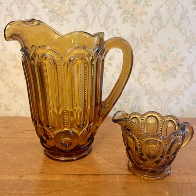 A Pair of Amber Pressed Glass Moon and Star Pitcher and Creamer