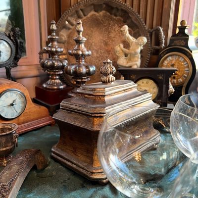 Collection of vintage decorative decor including a gilded wooden keepsake box, various mantle clocks, metal finials, stemware, and a...