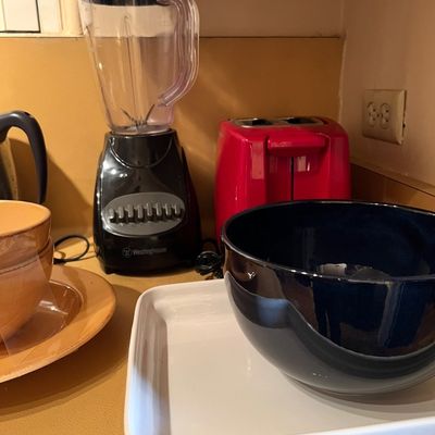 Selection of kitchen small appliances and servingware, including a black Westinghouse countertop blender, a red two-slice toaster, a...