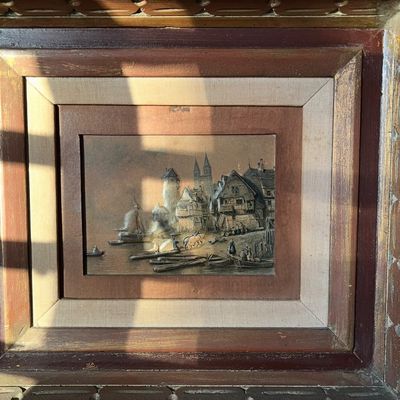 Framed vintage relief artwork depicting a European coastal town with ships, figures, and architectural details. Housed in a multi-layered...