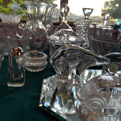 Collection of vintage clear crystal and glassware including a polar bear figurine, decanters, vases, and a salt shaker.