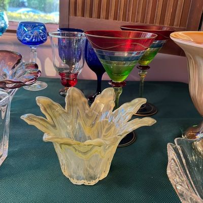 Collection of decorative glassware featuring a yellow swirled organic-form bowl, colorful hand-painted martini glasses, cut-to-clear...