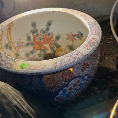 Large Chinese porcelain fishbowl planter featuring Imari-style floral patterns on the exterior and painted goldfish with aquatic flora on...