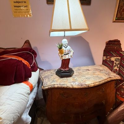 French Bombé style marble-top nightstand or chest featuring a porcelain figure lamp with an asymmetrical shade.