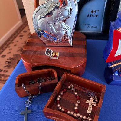 Sale Photo Thumbnail #15: Collection of religious items including a silver-plated heart-shaped Madonna and Child plaque, two wooden trinket boxes, and several rosaries.