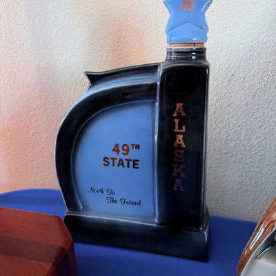 Sale Photo Thumbnail #19: Vintage ceramic Alaska 49th State commemorative decanter, featuring a blue and black glaze with a star-shaped stopper.